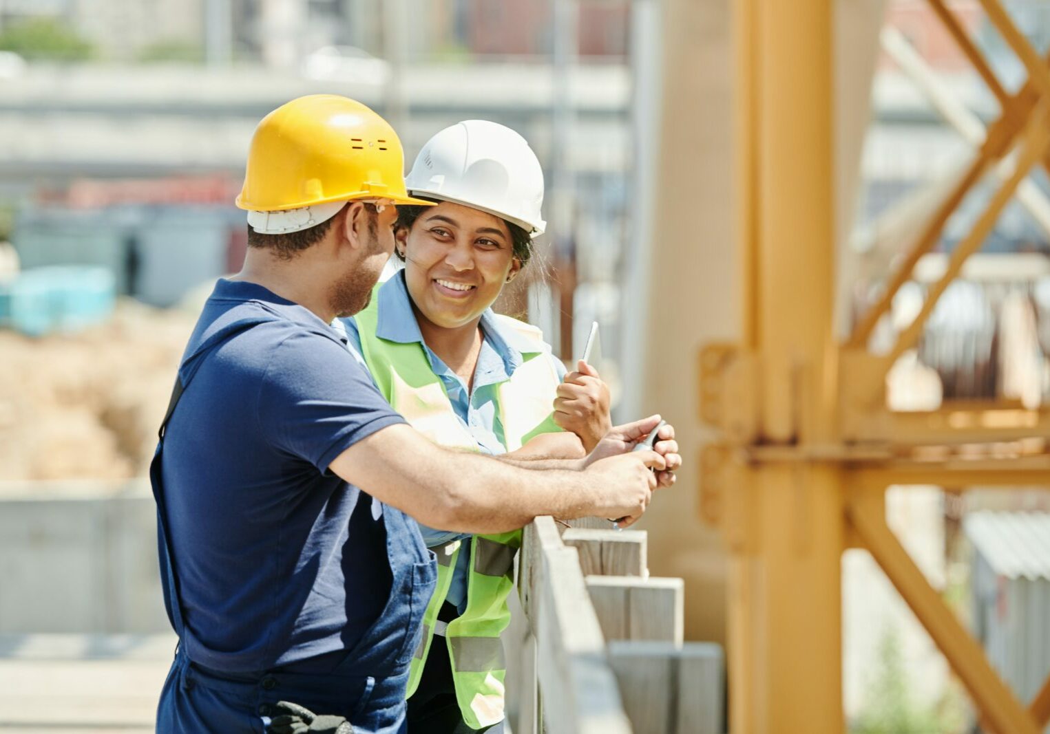 Two construction workers talking and smiling.